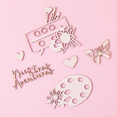 Elementos decorativos de madeira clara com tema artístico e floral sobre fundo rosa