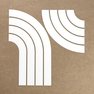 Dois moldes de papel branco com linhas arredondadas em superfície castanha