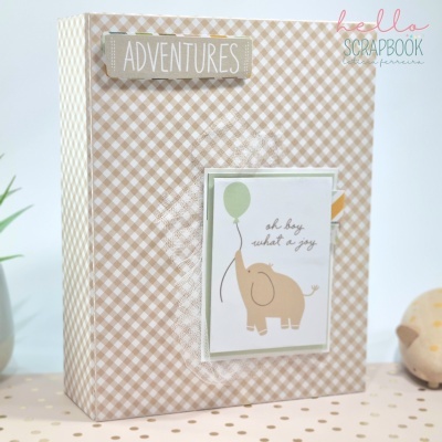 Caixa/álbum com padrão de quadrados beges e brancos e decoração com elefante e texto