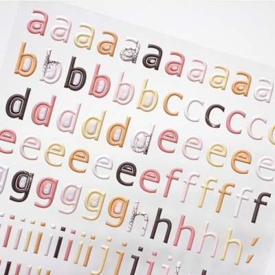 Folha com autocolantes de letras minúsculas coloridas e decoradas