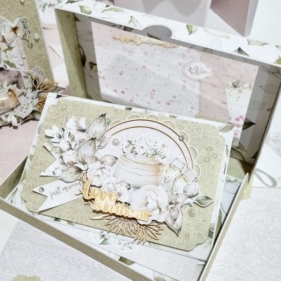 Cartão decorativo floral em tons bege e cinza com texto 'love is in the air'