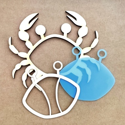 Formas metálicas de caranguejo em branco e azul num fundo bege