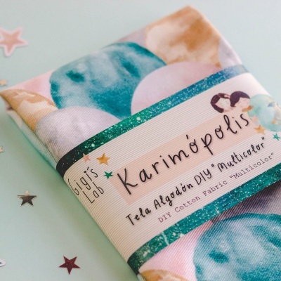 Pano de algodão com padrão de círculos azuis e bege e embalagem com texto em espanhol