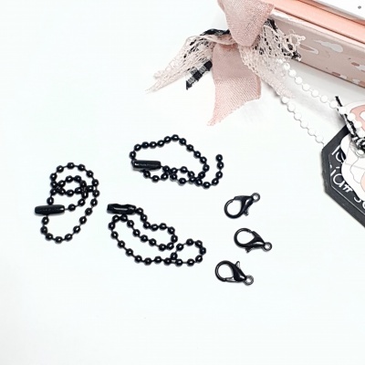 Três correntes de esferas pretas com fechos e três fechos isolados sobre fundo branco e objeto decorativo rosa