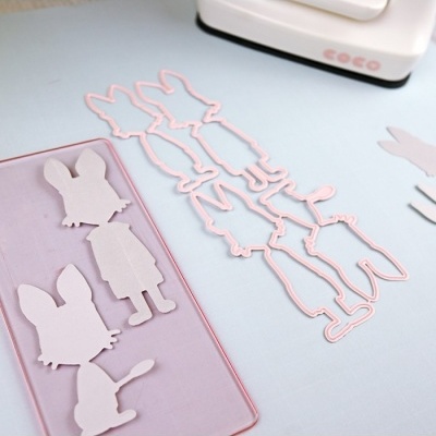 Moldes rosa claro de animais sobre superfície azul clara