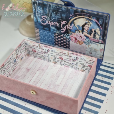 Caixa decorativa aberta com imagem 'Super Girl' e padrões coloridos.