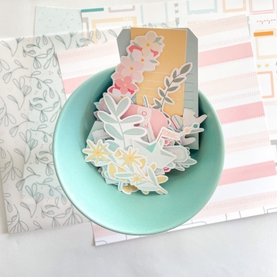 Etiquetas decorativas de papel em prato azul claro sobre fundo com padrões suaves