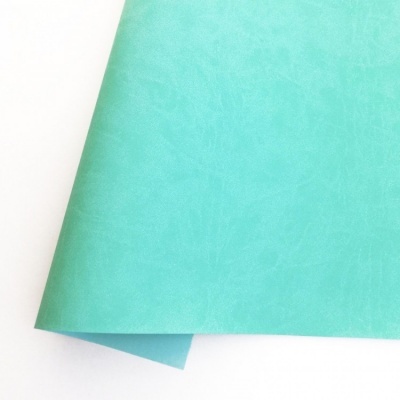 Papel ou tecido sintético turquesa com textura suave dobrado