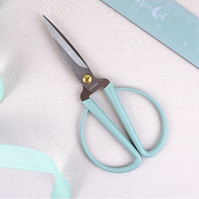 Tesoura azul claro com lâminas metálicas e régua azul