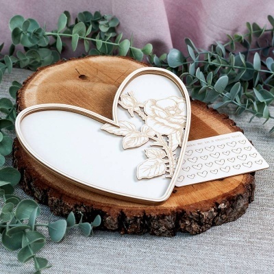 Prato decorativo em forma de coração sobre madeira e folhas verdes