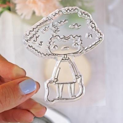 Selo transparente com desenho de boneca estilizada em traço preto