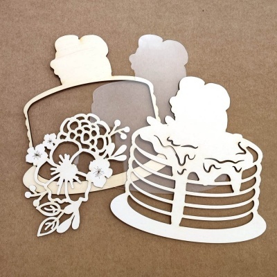 Recortes decorativos em papel branco com formas de bolos sobre fundo castanho