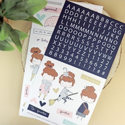 Folhas de autocolantes com ilustrações de raparigas, corações, palavras em francês e letras e números brancos em fundo azul.