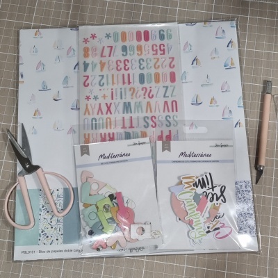 Conjunto de papelaria para scrapbooking com veleiros, autocolantes de letras e números, recortes coloridos, tesoura rosa e ferramenta de corte.