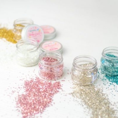 Frascos pequenos com glitters coloridos espalhados