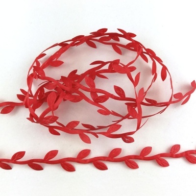 Fita decorativa vermelha com padrão de folhas sobre fundo branco