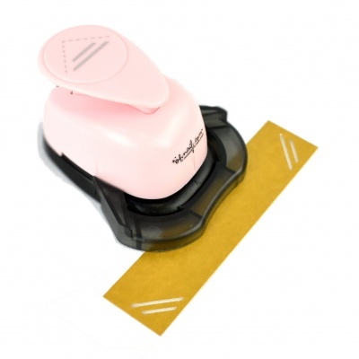 Ferramenta de carimbo rosa e preto com padrão de linhas brancas num papel castanho