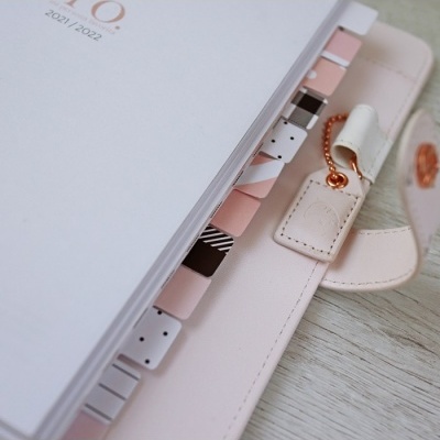 Caderno ou agenda com abas coloridas e capa rosa claro com fecho de botão