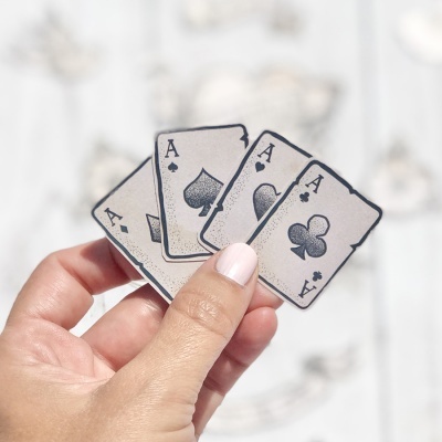 Mão segura quatro cartas de baralho envelhecidas com ases de diferentes naipes