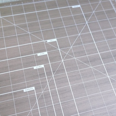 Tapete de corte com marcações de medidas em fundo madeira