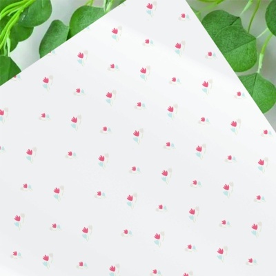 Papel decorativo branco com pequenas flores vermelhas e folhas verdes