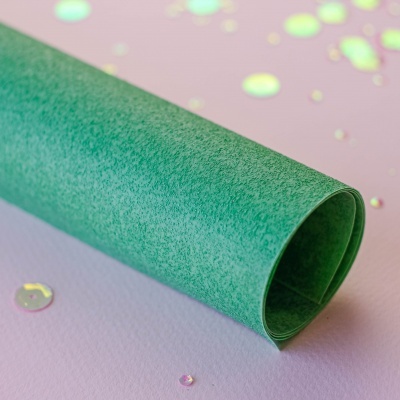 Rolo de papel texturado verde com gotas brilhantes no fundo lilás