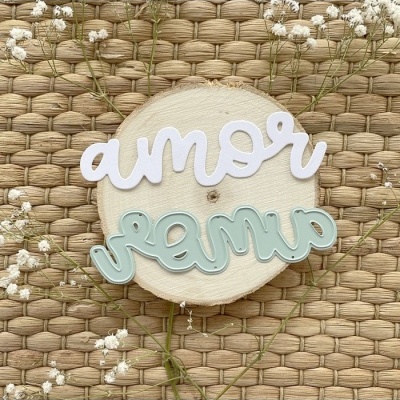 Palavras recortadas 'amor' em branco e verde claro sobre disco de madeira e base de fibras entrelaçadas