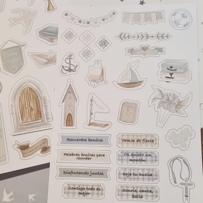 Folha de autocolantes com desenhos a cores, frases em espanhol e elementos náuticos e festivos
