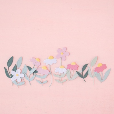 Flores decorativas em papel de várias cores sobre fundo rosa