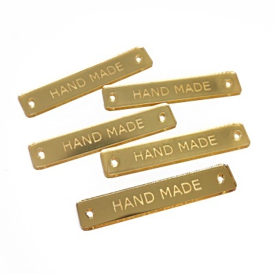Etiquetas douradas retangulares com texto HAND MADE
