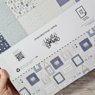 Conjunto de papéis decorativos em tons de azul, cinzento e branco com embalagem branca e texto em português