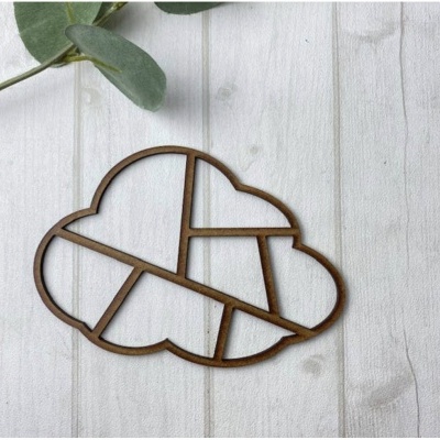 Suporte decorativo de madeira em forma de nuvem com cortes geométricos sobre superfície de madeira clara