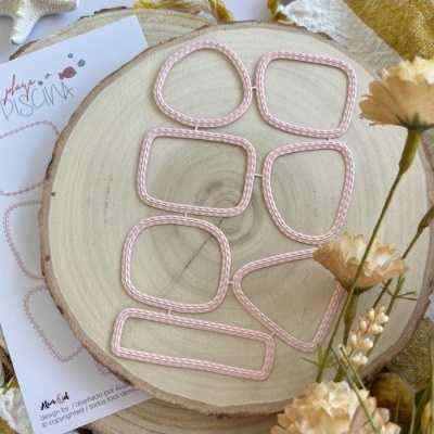 Elásticos de tecido rosa claro sobre tábua de madeira com flores secas e cartão