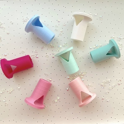 Sete pedais de bicicleta coloridos em plástico sobre superfície clara com estrelas