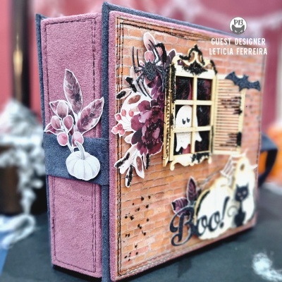 Livro decorativo de Halloween com capa roxa e detalhes de papel com fantasmas e aranha