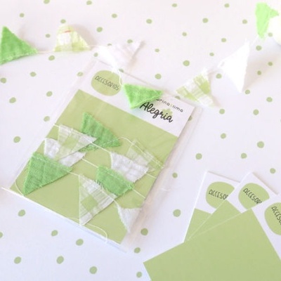 Guirlanda triângulo de tecido verde e branco com etiqueta Alegria sobre fundo branco com bolinhas verdes