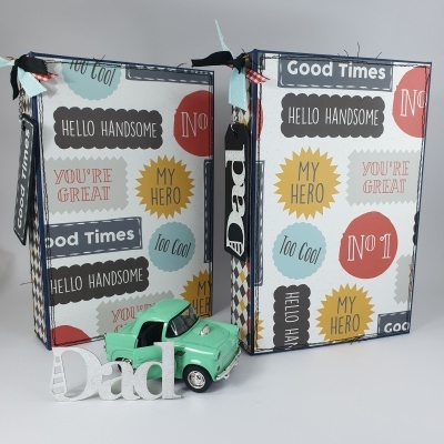 Caixas de presente coloridas com textos motivacionais, modelo de carro verde e decorativo branco com texto 'Dad'.