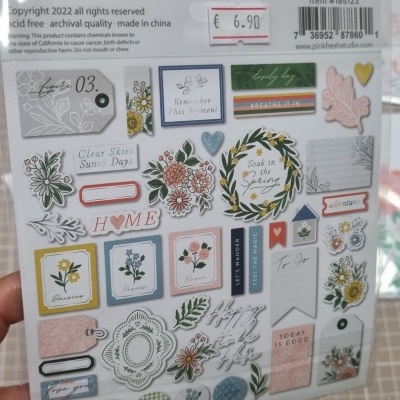 Folha de autocolantes decorativos florais coloridos com textos em inglês em embalagem plástica.