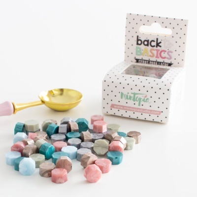 Conjunto de contas coloridas facetadas e colher dourada com embalagem branca pontilhada