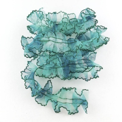 Fita decorativa azul e verde com bordas onduladas sobre fundo branco