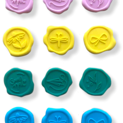 Doze selos de cera coloridos com desenhos e texto