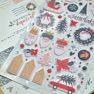 Conjunto de adesivos de Natal com vários motivos festivos em cores vermelha, branca, cinza e dourada, em embalagem transparente.