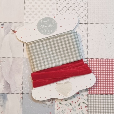 Duas fitas, uma xadrez cinza e branca e outra vermelha lisa, enroladas em cartolina branca com padrão de pontos cor-de-rosa e coração recortado.