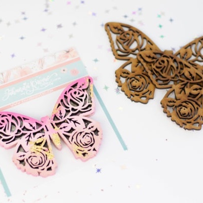 Marcadores de livros em forma de borboleta com padrão floral, um de madeira castanha e outro rosa com embalagem