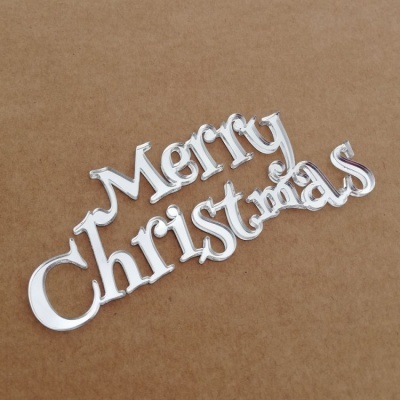 Ornamento prateado 'Merry Christmas' em fundo castanho