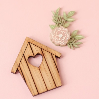 Casinha decorativa em madeira com corte de coração e flor rosa com folhas verdes