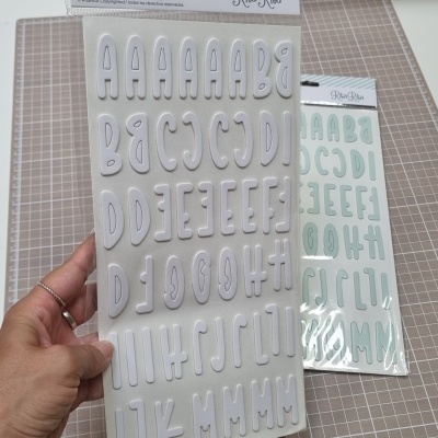 Folhas de autocolantes de letras em cartão impresso branco e azul claro da marca Rita Rita embaladas em plástico