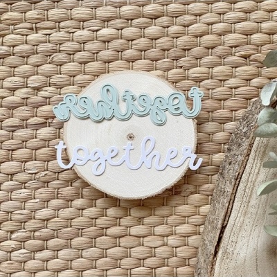 Palavras decorativas 'together' azul e branco sobre fatia de madeira em tecido entrelaçado natural