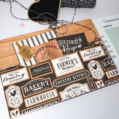 Folha com etiquetas decorativas de estilo vintage e cartão castanho com corda preta e branca ao lado.