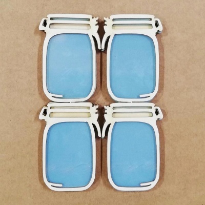 Quatro ímanes em forma de frascos azuis com moldura branca